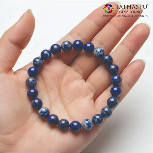 Authentic Original Lapis Lazuli Bracelet at Tathastu Gems Lounge held on an open palm displaying rich blue beads with gold pyrite flecks.