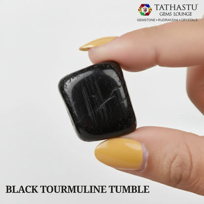 Natural polished Black Tourmaline Tumble stone held in hand for negative energy protection and grounding - Tathastu Gems Lounge