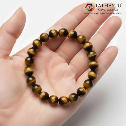 Authentic Original Tiger's Eye Bracelet at Tathastu Gems Lounge held on an open palm displaying silky luster golden and brown silky-banded gemstone beads.