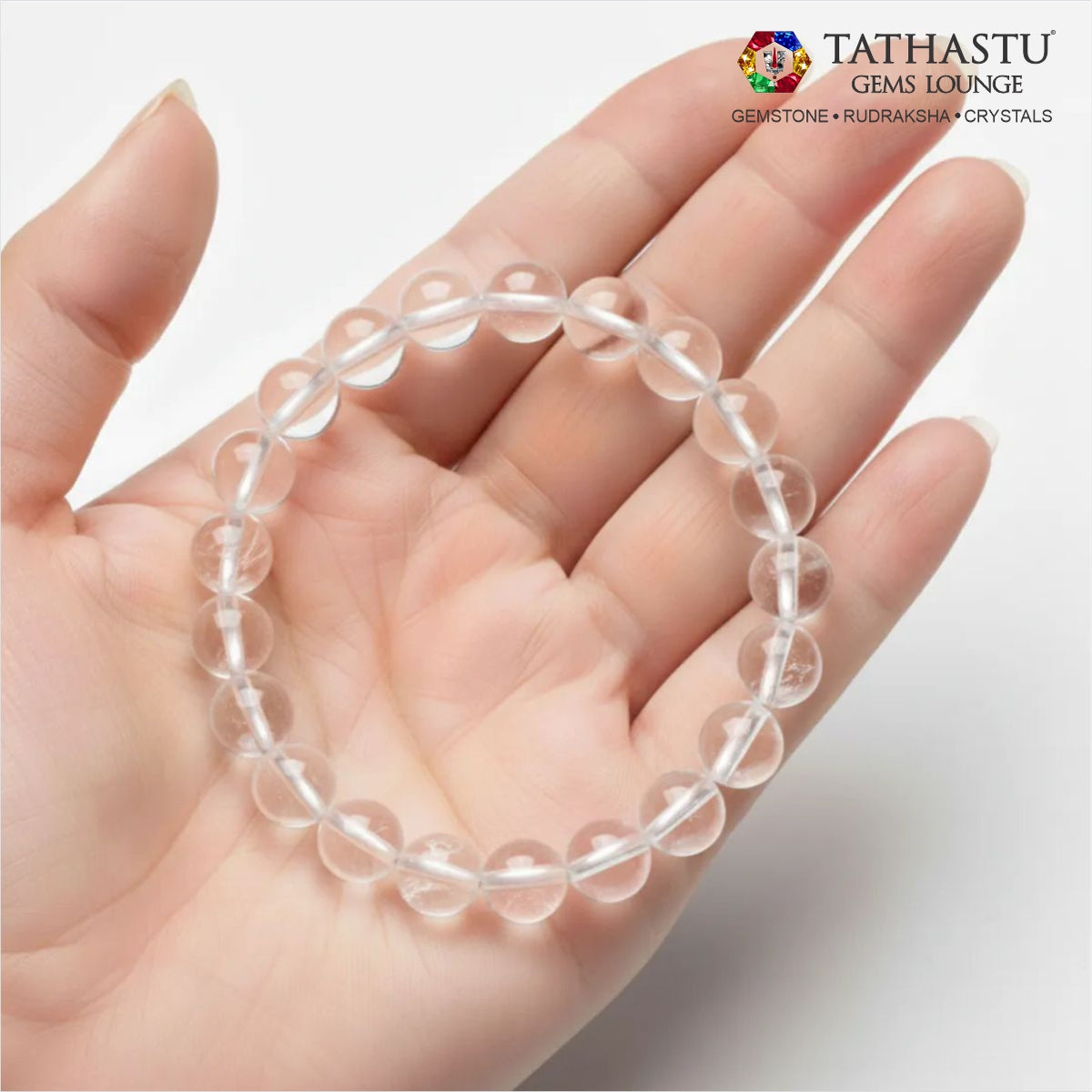 Authentic Original Clear Quartz Bracelet at Tathastu Gems Lounge held on an open palm displaying high-clarity clear glass-like crystal beads.
