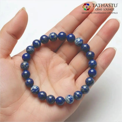 Authentic Original Lapis Lazuli Bracelet at Tathastu Gems Lounge held on an open palm displaying rich blue beads with gold pyrite flecks.