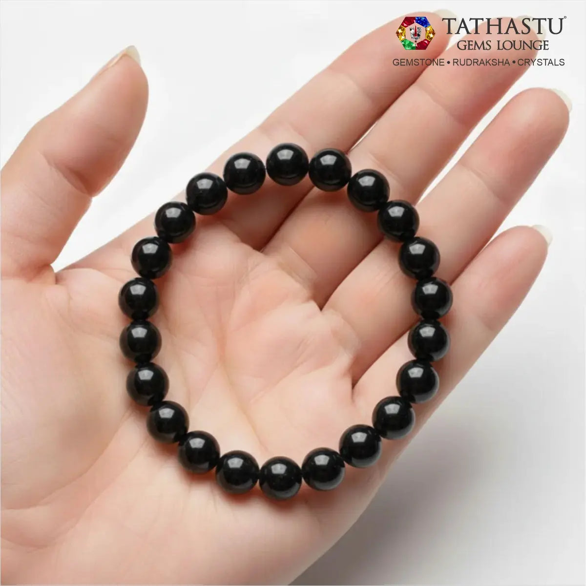 Authentic Original Black Tourmaline Bracelet at Tathastu Gems Lounge held on an open palm displaying glossy natural black gemstone beads.
