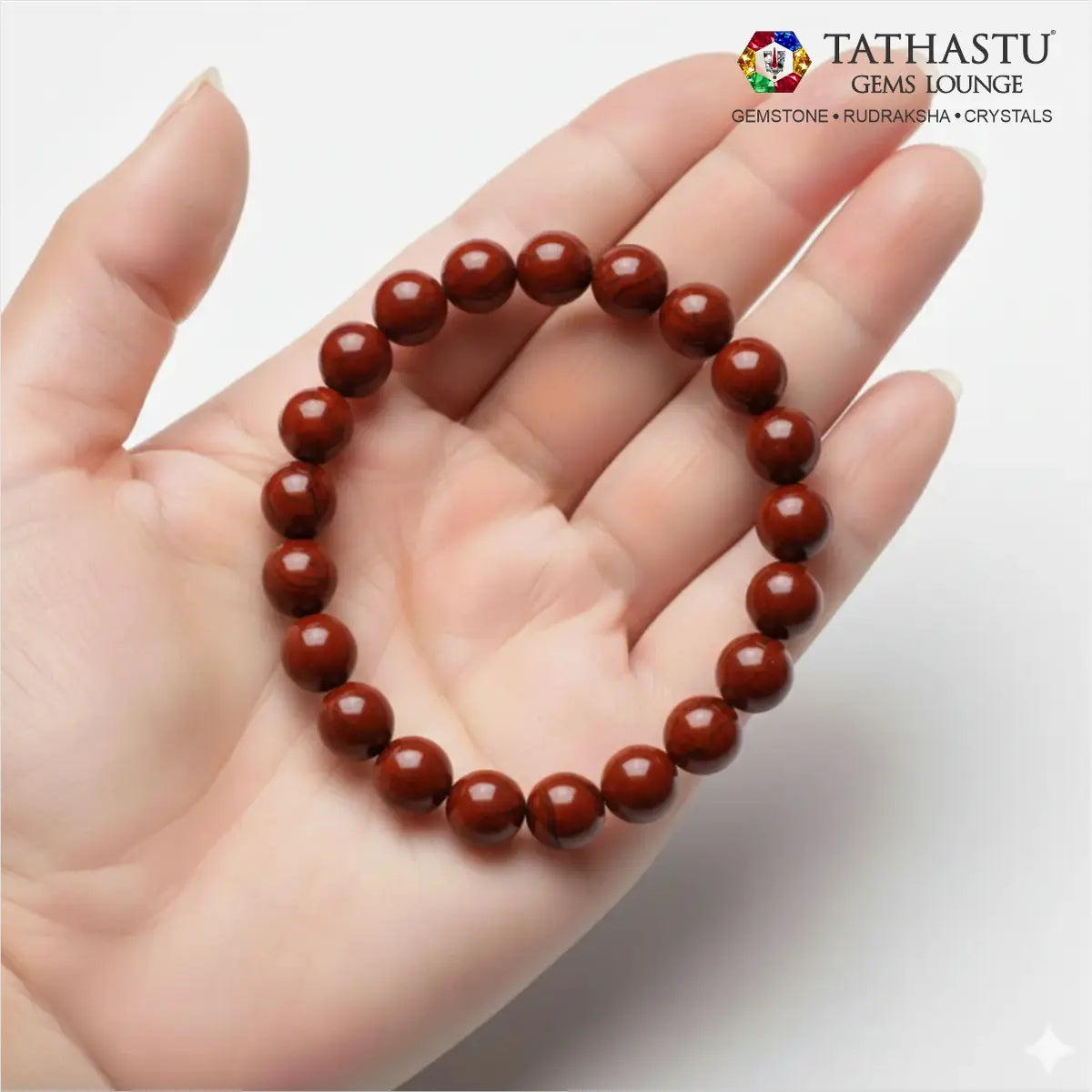 Authentic Original Red Jasper Bracelet at Tathastu Gems Lounge held on an open palm displaying rich opaque brick-red gemstone beads.